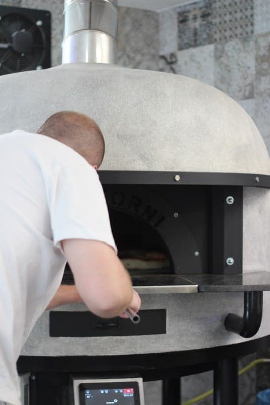 Pizzaiolo pri kupolovej peci